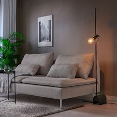 a living room scene with focus on the couch and floor lamp in the foreground