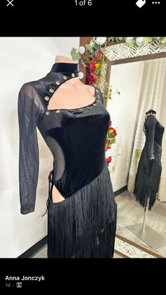 a mannequin wearing a black dress in front of a mirror