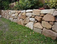 a stone wall is shown in the grass