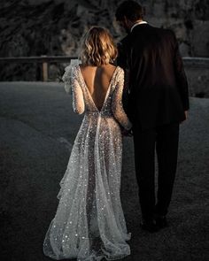 a man and woman are walking down the road in their wedding dresses with sequins on them