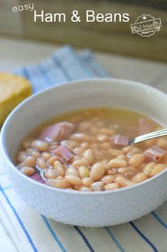 a bowl of ham and beans soup with bread on the side