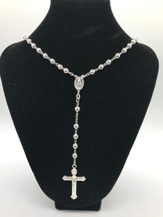 This silver rosary crusifix with medium silver beads is new in good condition with all original pieces and components. Entire Measurement in Length 18 1/2" inches (Top to Bottom) Necklace Chain Portion Measurements 13" inches long for each stran of beads = (26" inches chain with both sides)  Measurement from the Top of the Oval Shape Pendant with Mary inside to the Bottom of Cross 5 3/4" inches Cross Pendant Measurements: 2" inches height including bale 1" inch wide. Stamped silver 925  in worki Silver Cross-shaped Jewelry With Beaded Chain, Silver Cross Jewelry With Beaded Chain, Silver Cross Jewelry With Beads, Sterling Silver Cross Rosary In Silver, Silver Sterling Silver Cross Rosary, Silver Cross Necklace With Beaded Chain, Silver Rosary With Miraculous Medal And Round Beads, Silver Cross Rosary Bracelet, Silver Cross Rosary As Gift