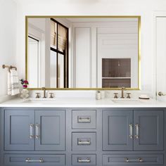 a bathroom with two sinks and a large mirror