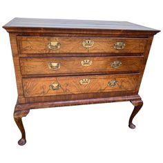 an antique chest of drawers with brass hardware on the top and bottom, in walnut