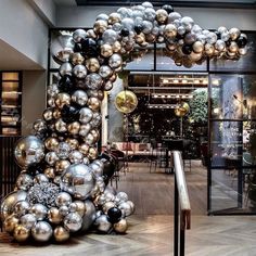 a large number of silver and gold balloons in the shape of a dog on display