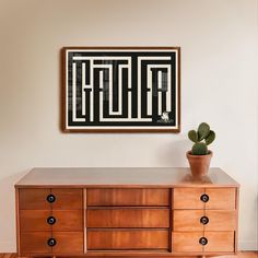 a wooden dresser with a potted plant on top of it next to a painting