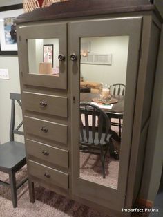 an armoire with mirrored doors and drawers in a room next to a dining table