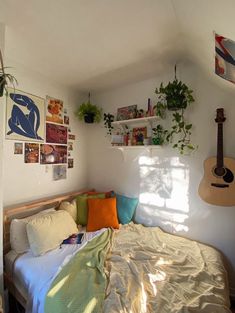 a bed with lots of pillows and plants on the wall