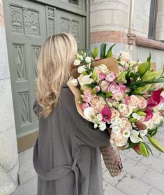 a woman holding a large bouquet of flowers