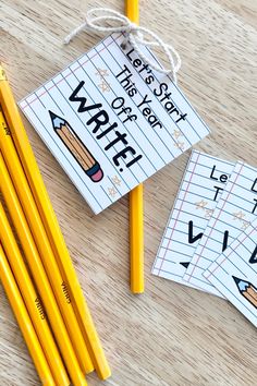 two yellow pencils and some writing paper on a wooden table next to each other