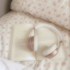 an open book with headphones laying on top of it