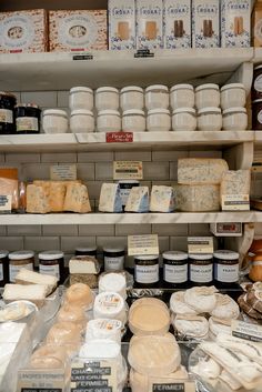 the shelves are filled with different types of cheese