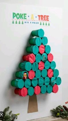 there is a christmas tree made out of toilet paper rolls on the wall next to some candy