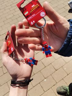 someone is holding up some legos to show off their keychain charms