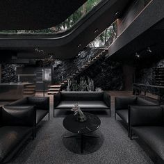 a living room filled with black furniture and lots of windows