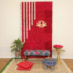 a living room with red and white decor on the wall next to a blue bench