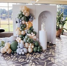 a large balloon christmas tree in the middle of a room with many balloons on it