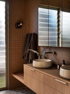 a bathroom with two sinks and mirrors in it