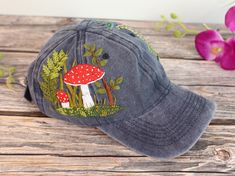 a hat with a mushroom on it sitting on a wooden table next to flowers and purple orchids