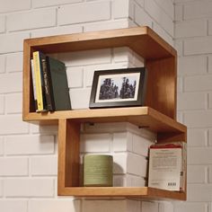 a shelf that has some books and other items on it in front of a brick wall