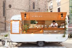 a man standing in front of a food truck with lights on it's side