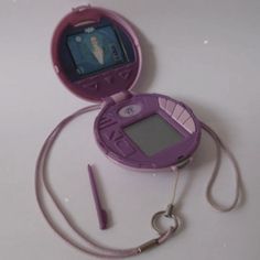 a purple electronic device sitting on top of a white table next to a lanyard