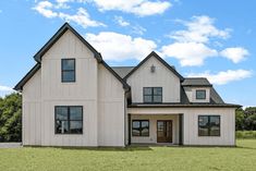 a large white house sitting on top of a lush green field