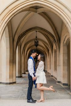 a man and woman standing under an archway