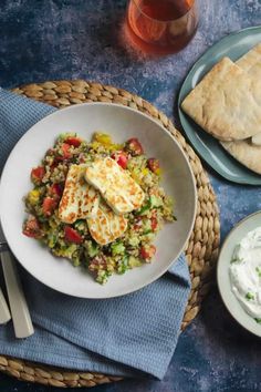 an image of a plate of food on a table with text overlay that reads mediterranean halloumi and bulgur wheat salad