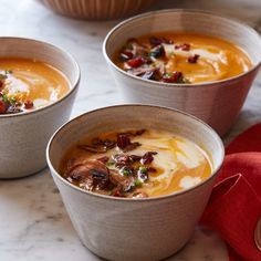 three bowls filled with soup on top of a table