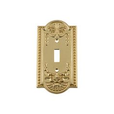 an ornate light switch plate cover in gold