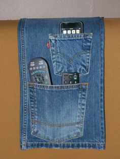 there is a cell phone in the pocket of a pair of jeans with remote controls