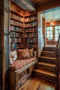 a couch sitting in front of a bookshelf filled with lots of books next to a stair case