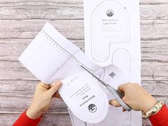 someone cutting out a pattern with scissors on a piece of paper