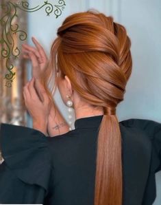 a woman with long red hair in a ponytail