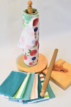 a roll of toilet paper sitting on top of a wooden tray next to napkins and a rolling pin