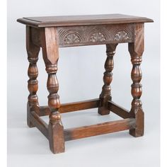 an old wooden table with turned legs and carvings on the top, against a white background