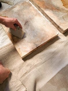 a person using a sanding tool on wood planks to finish up a piece of art work