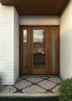 the front entrance to a house with two doors and brick walkway leading up to it