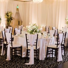 the tables are set with white linens and centerpieces for an elegant wedding reception