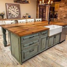 a large kitchen island with a sink in the middle and a clock on the wall above it