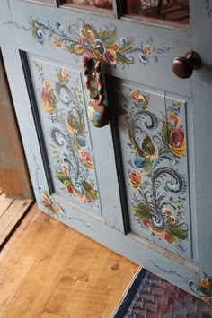 the door is painted blue and has floral designs on it, as well as an ornate handle