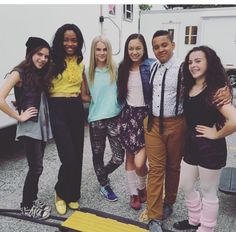 a group of young people standing next to each other in front of a food truck