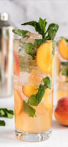 two glasses filled with peaches and mint garnish