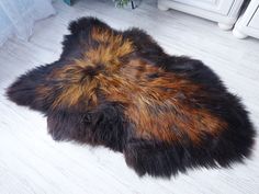 a brown and black animal skin rug on the floor next to a radiator