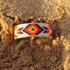 A metallic cuff with a beaded design in brilliant colors calling out a true southwest feel. Band is 2 3/8 inches in diameter, Cuff is approximately 1 inch wide. Land Of Enchantment, Beading Ideas, Black Orange, Brilliant Colors, Orange Black, Cuff Bracelet, Embroidered Friendship Bracelet, Enchanted, Loom