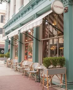 the outside of a coffee shop with tables and chairs lined up on the side walk