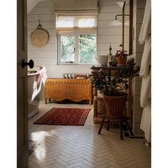 a bathroom with white walls and flooring has a rug on the floor next to it