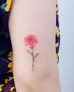 a small pink flower on the back of a woman's right arm and leg