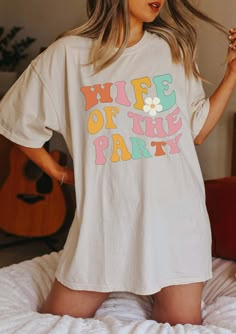 a woman wearing a white t - shirt with the words wife of the party printed on it